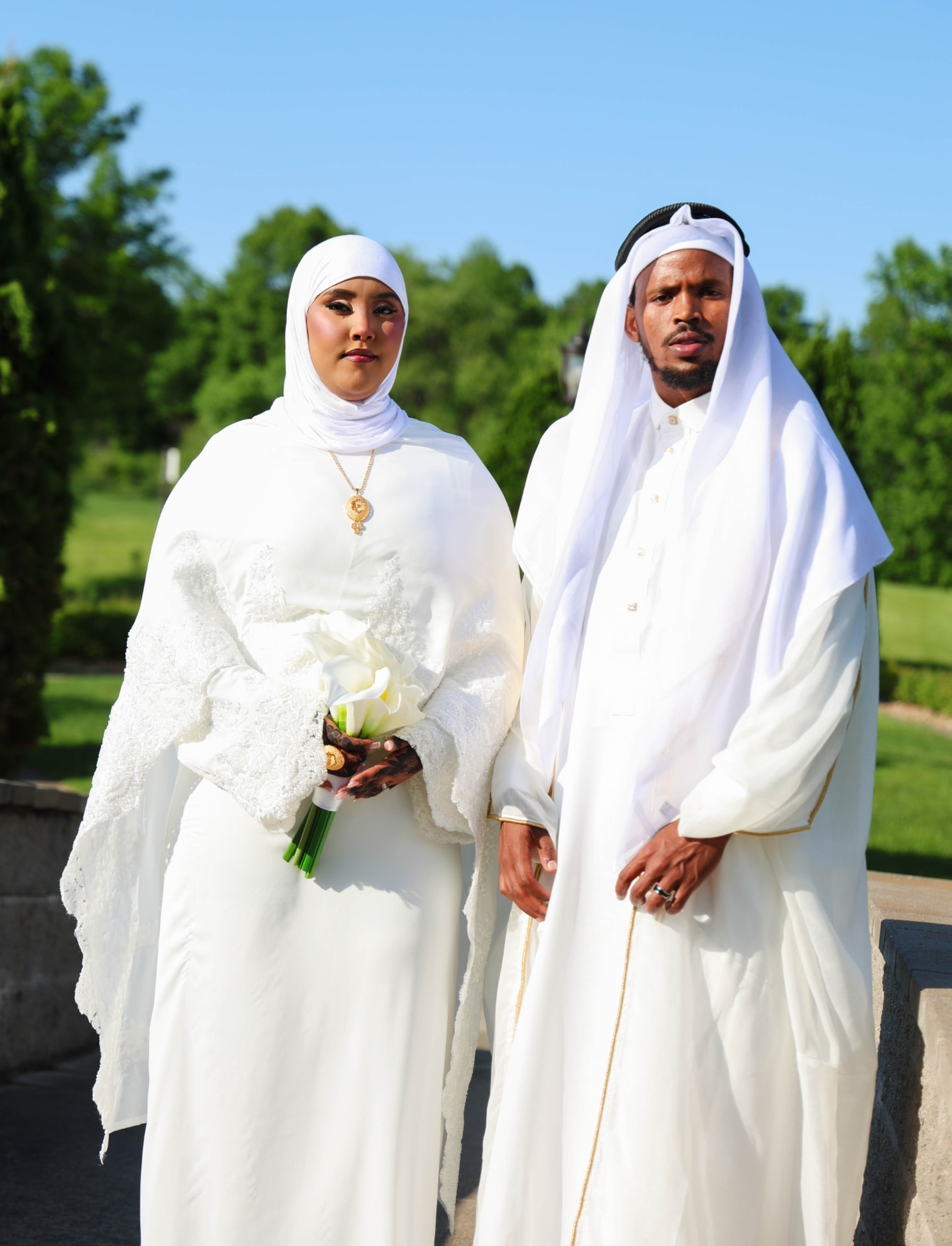 Bride and groom in white attire photographed outdoors by Xirfad Studio